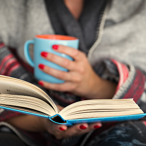 woman reading a book holding a cup of tea to manage emotions | help to learn how to manage intense emotions with therapy in Fair Oaks, CA
