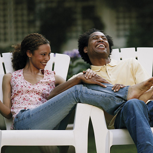 couple sits on lawn chairs and smiles at each other. They go to a couples retreat in California with a couples therapist at the relationship therapy center to improve their relationship